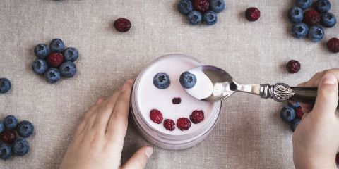 Child Eating a Smiley Faced Decorated Yoghurt