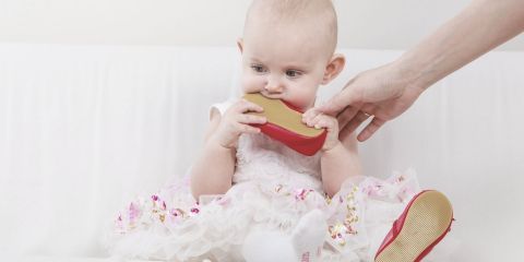 Baby wearing one shoe and eating another